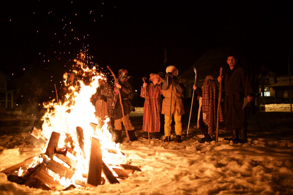 Shepherds in costume around bonfire